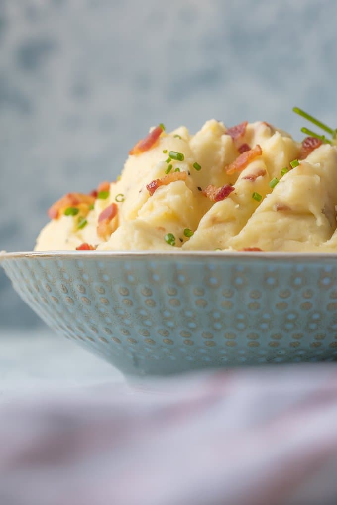 A bowl of cheesy mashed potatoes with goat cheese & bacon