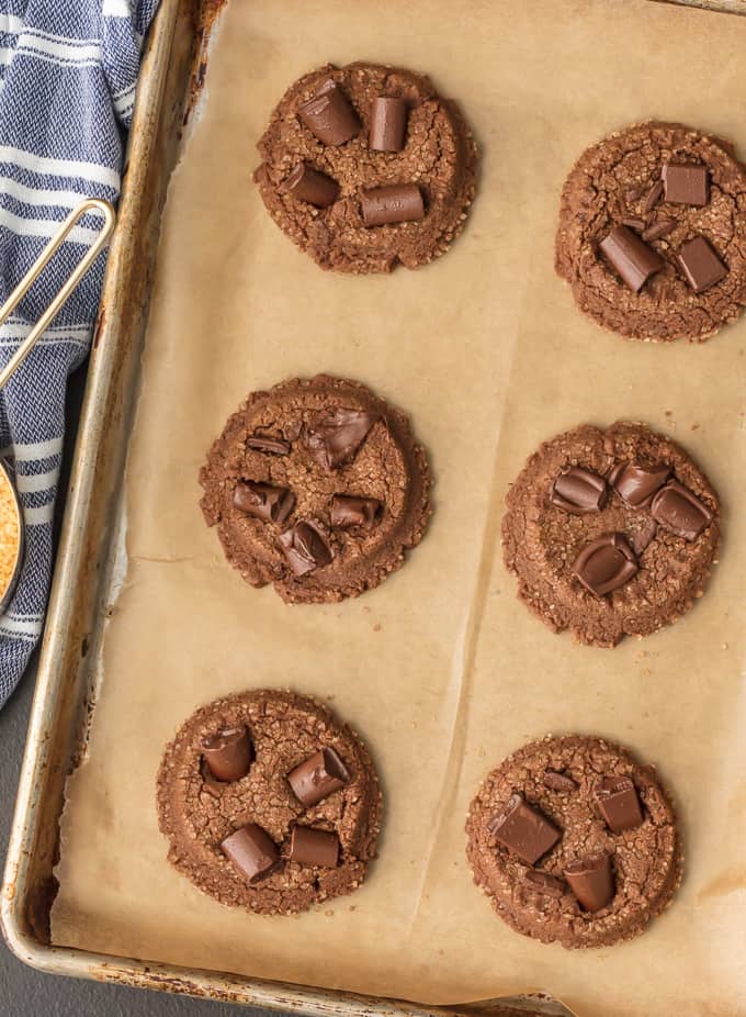 chocolate sugar cookies arranged on a baking tray covered with parchment paper