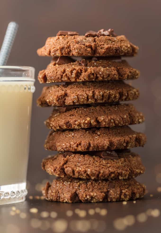 a stack of chocolate cookies next to a glass of milk