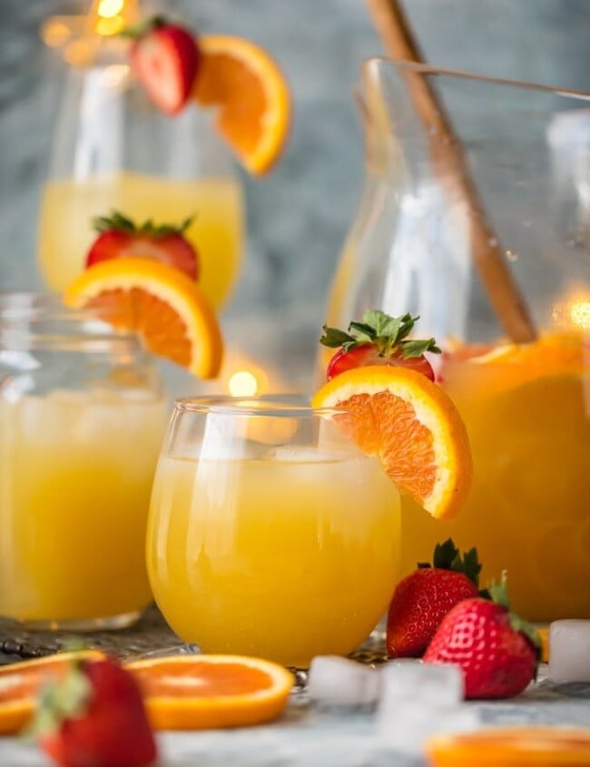 cups of grapefruit sangria in front of a pitcher of sangria