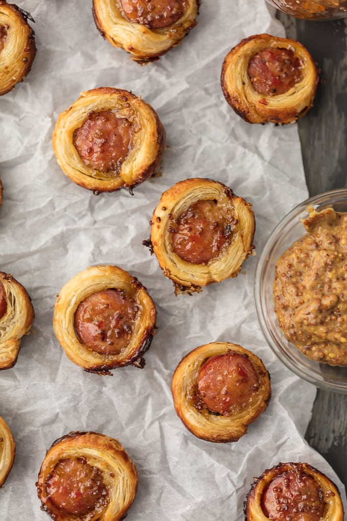 Mini sausage rolls arranged on parchment paper