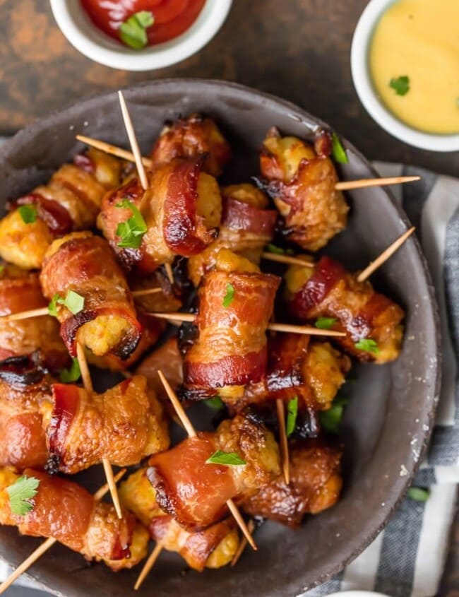 Bacon Wrapped Tater Tots are a must make appetizer for any celebration. You should make a triple batch of these SWEET & SPICY BACON WRAPPED TATER TOTS because they're always gone in seconds! Spices and and a little sweetness make this easy bacon wrapped appetizer a favorite for the holidays and tailgating. Tater Tots have never been better. SO ADDICTING!