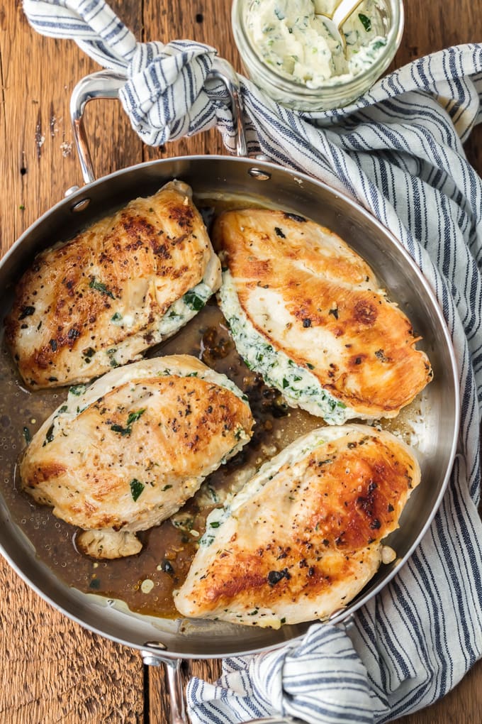 Spinach Stuffed Chicken Breast in pan with blue and white striped dish towel