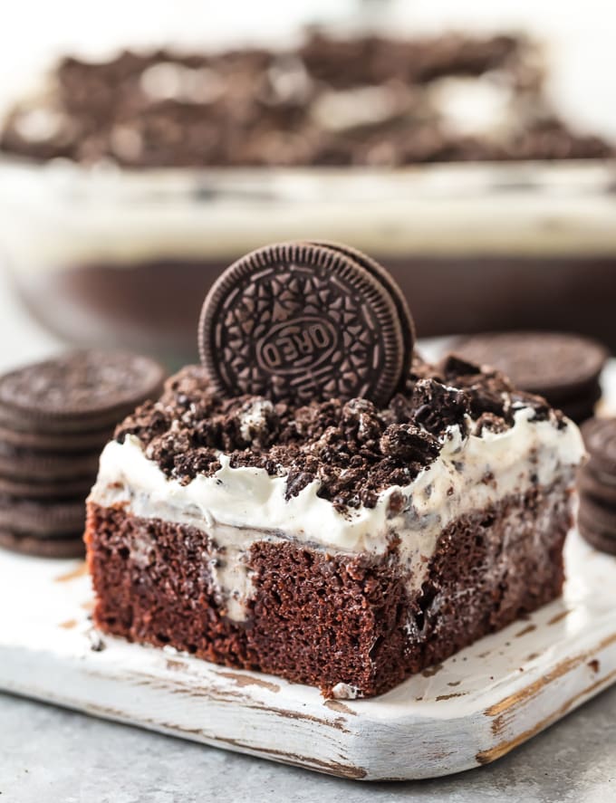 piece of oreo poke cake on a wooden board