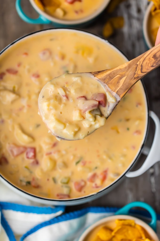 Spoonful of cheesy chowder above a large pot of chowder