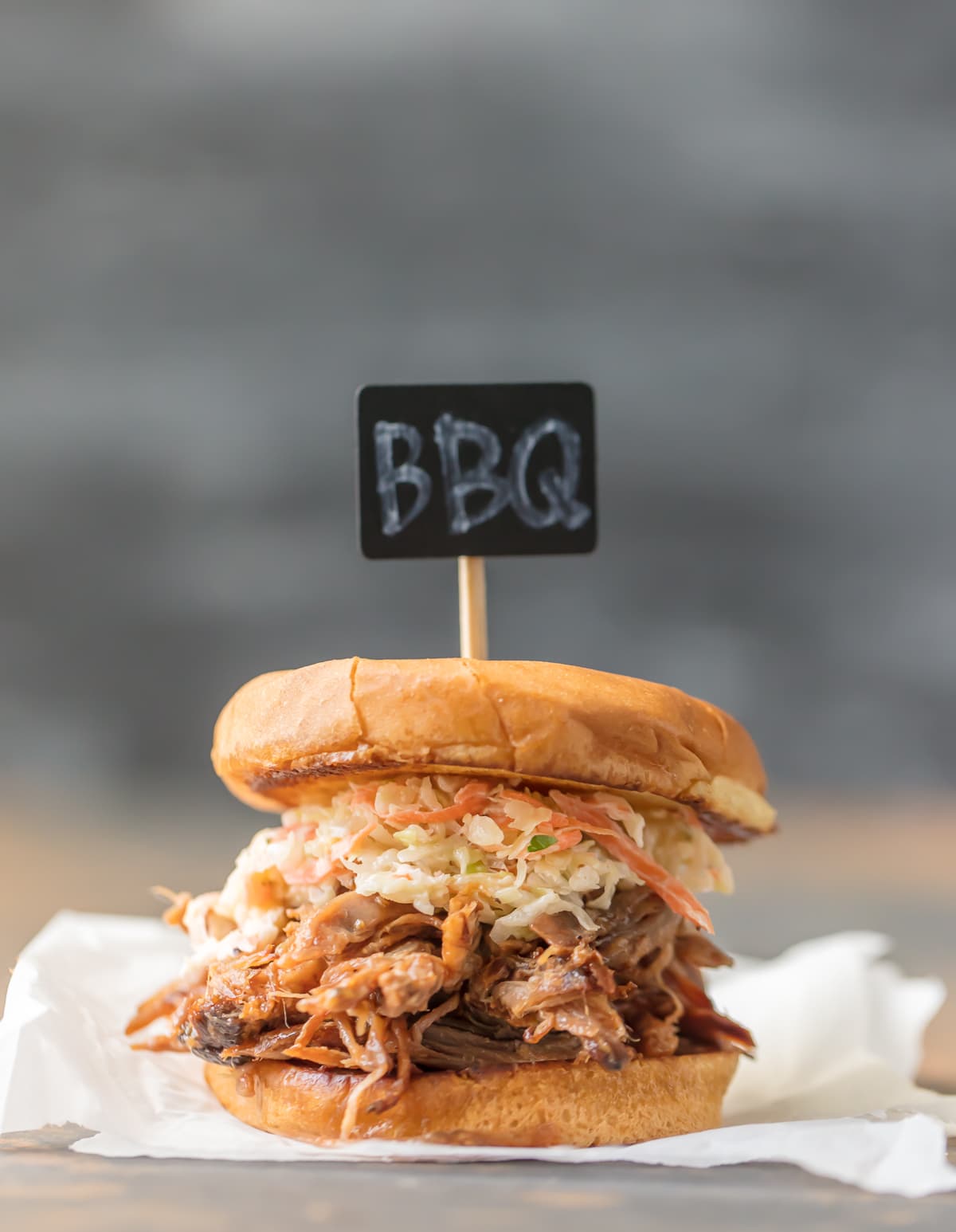 Close up of BBQ pork sandwich with "BBQ" sign 