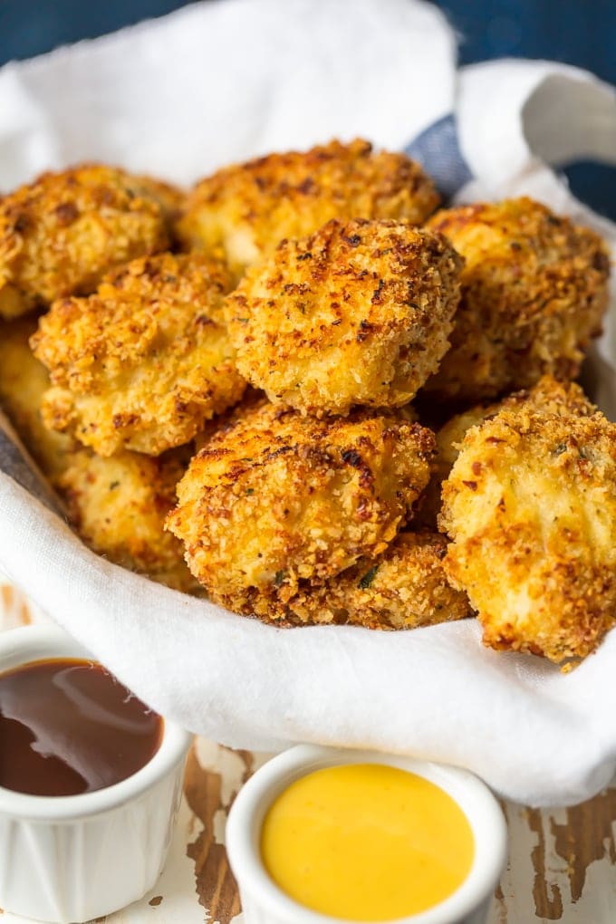 baked chicken nuggets in a basket with dipping sauces