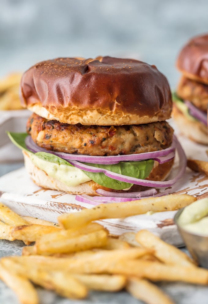 finished chicken burgers on pretzel bun with fries