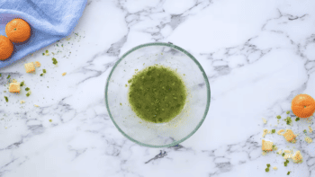 green cider vinaigrette in a glass bowl on a marble table.