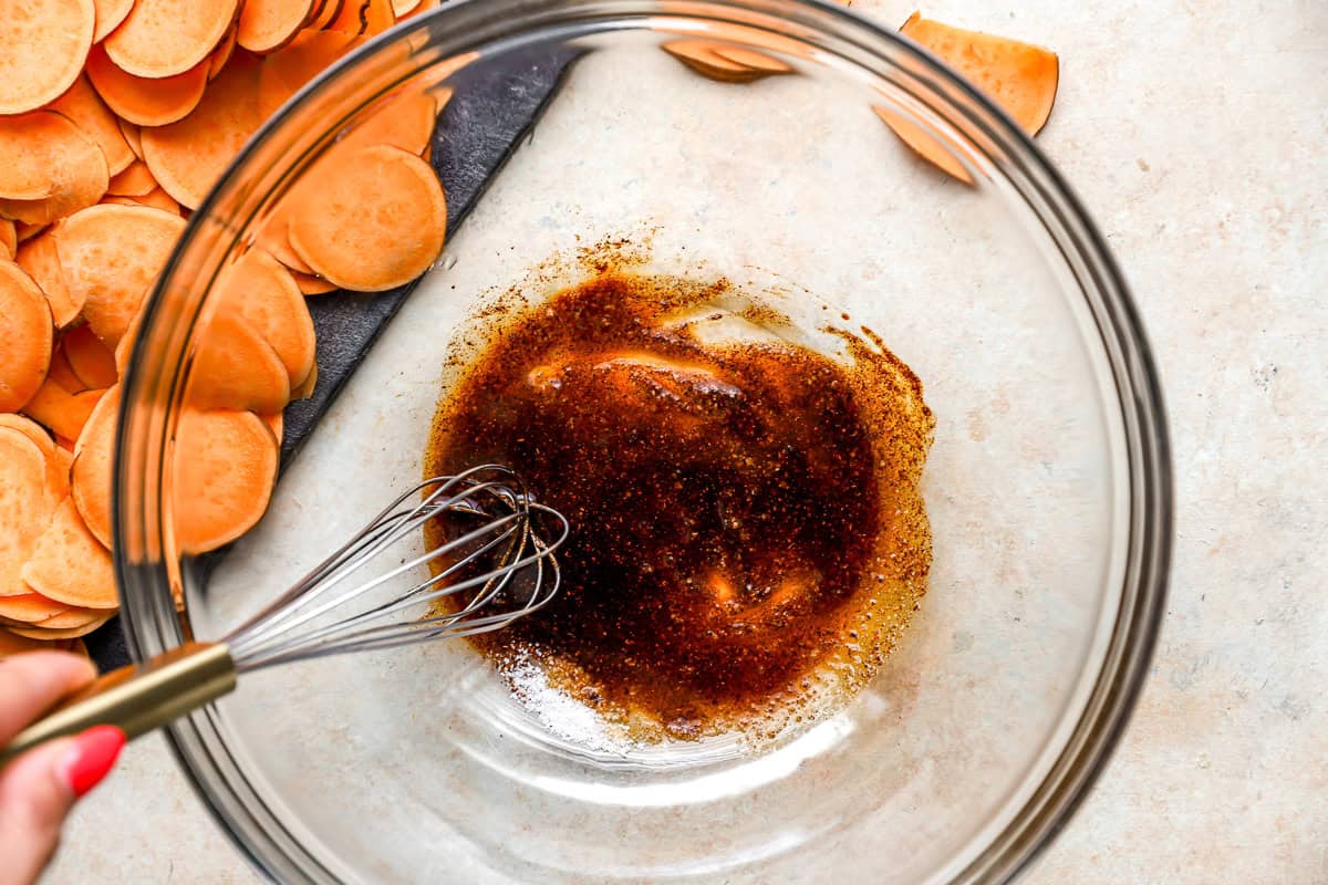 seasoned olive oil in a glass bowl with a whisk.