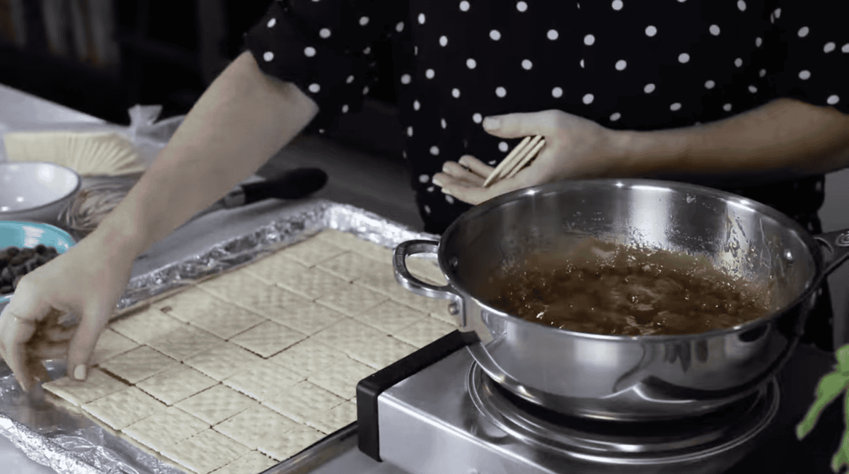 placing saltine crackers on a lined baking sheet.