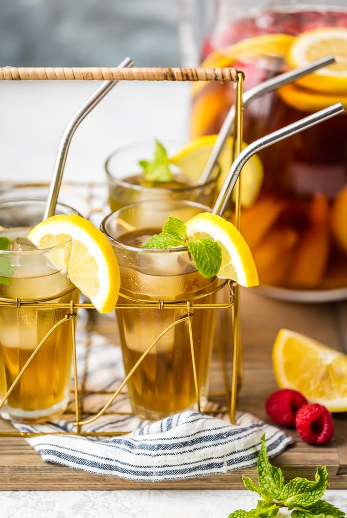 A drink caddy with 3 glasses full of sweet tea sangria