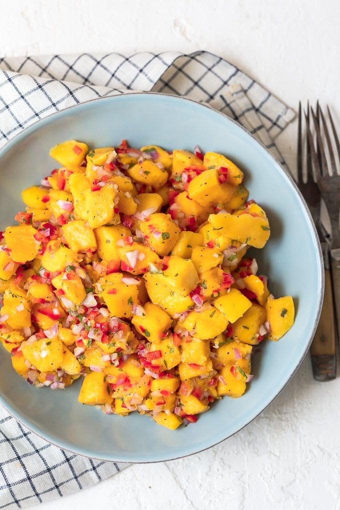 Easy mango salsa mix in a blue bowl