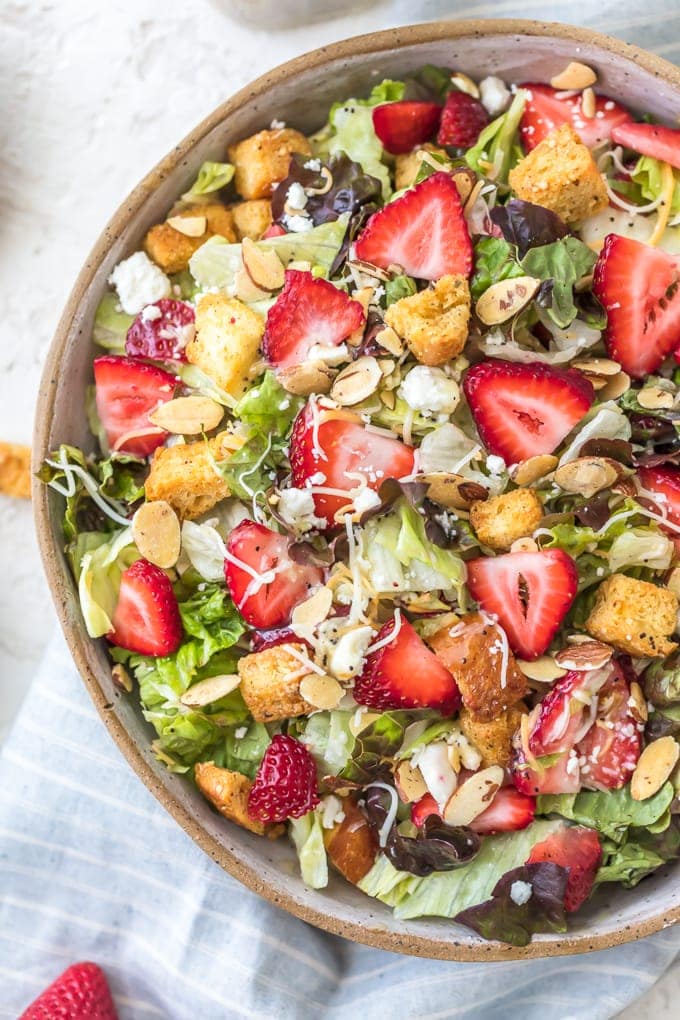 Strawberry Poppyseed Salad topped with fresh strawberries, croutons, feta, and more