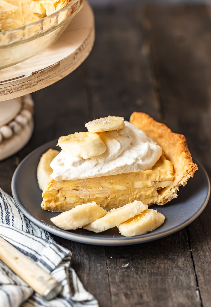 A slice of banana cream pie topped with bananas and whipped cream