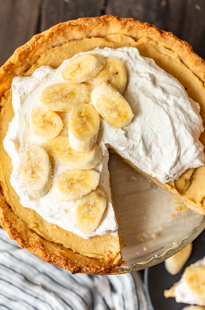 A banana cream pie topped with whipped cream and sliced bananas