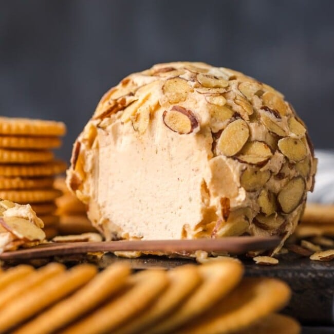 cheese ball on plate with crackers surrounding it