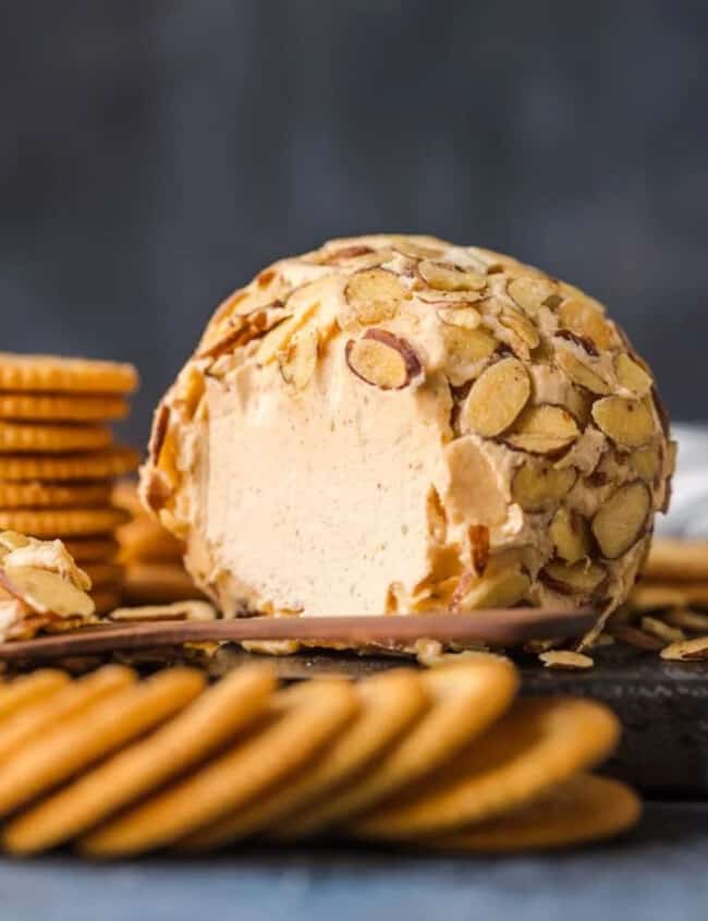 Almond cheese ball recipe with crackers on a cutting board.