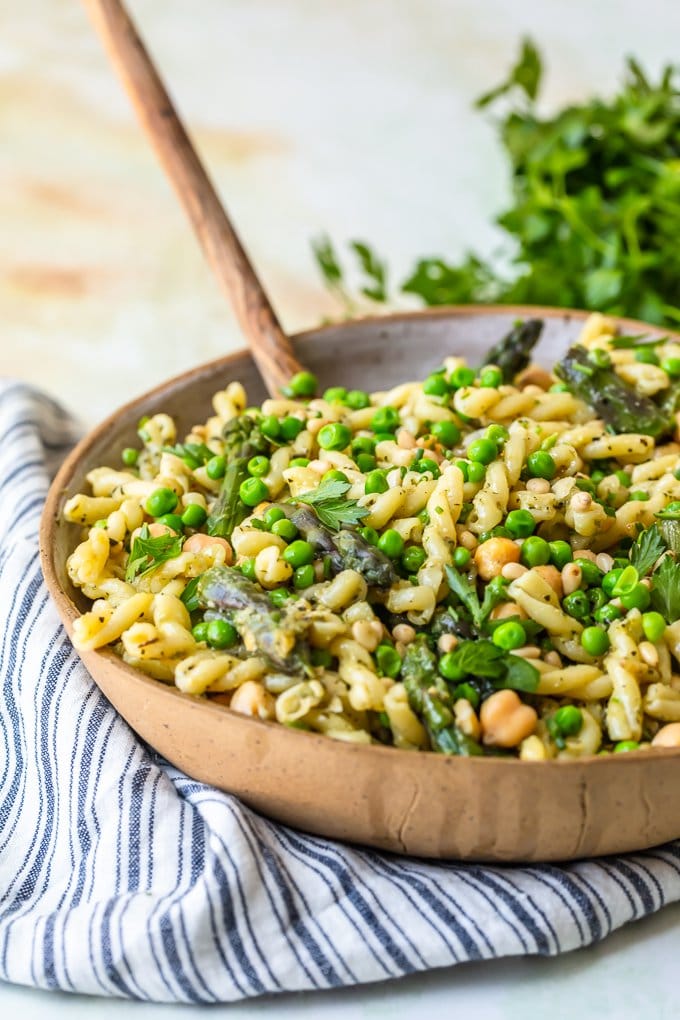 Pasta salad in bowl with wooden spoon