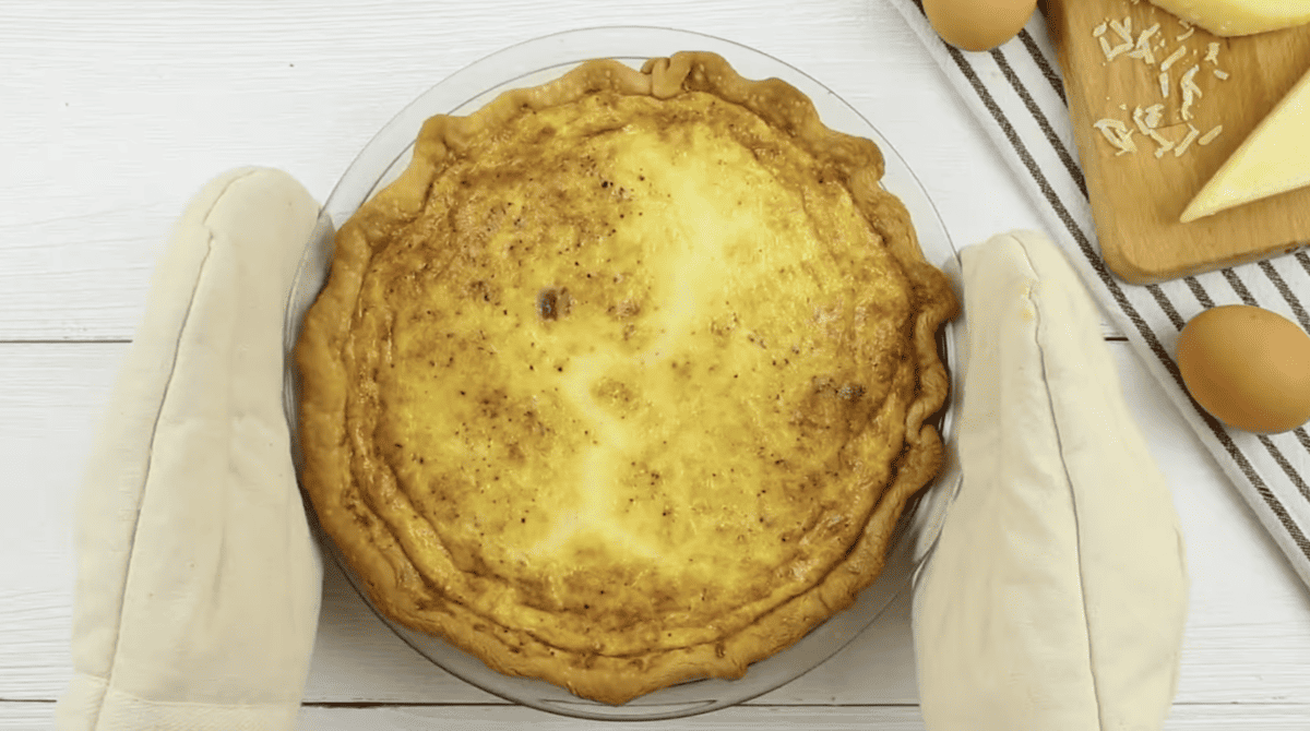 baked quiche lorraine on a white background.