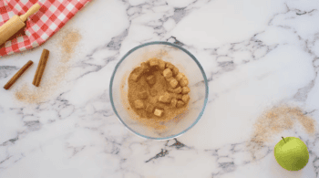 cubes of butter tossed in cinnamon and sugar in a glass bowl.