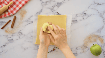 stuffing an apple half with butter and cinnamon sugar.