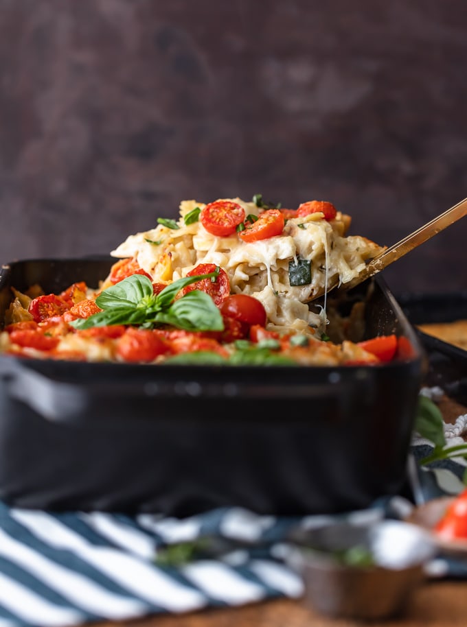 Scooping chicken alfredo pasta out of a casserole dish