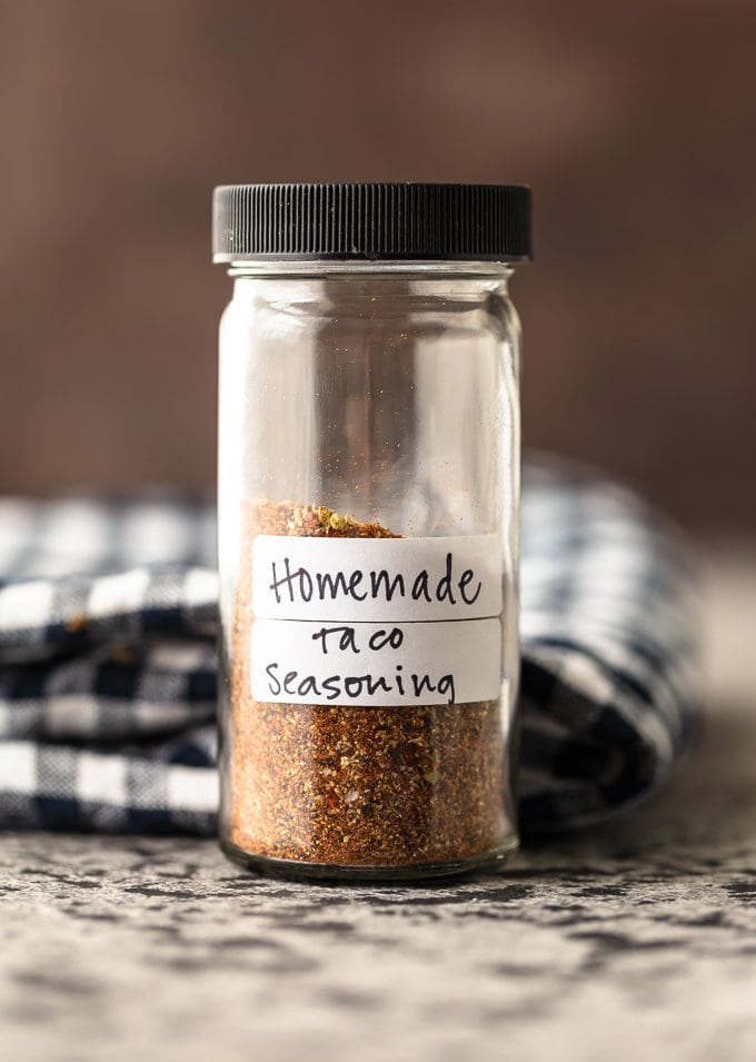 A glass spice jar filled with homemade taco seasoning