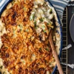 A green bean casserole dish with a spoon on top.