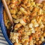 Homemade turkey stuffing in a blue dish with a wooden spoon.