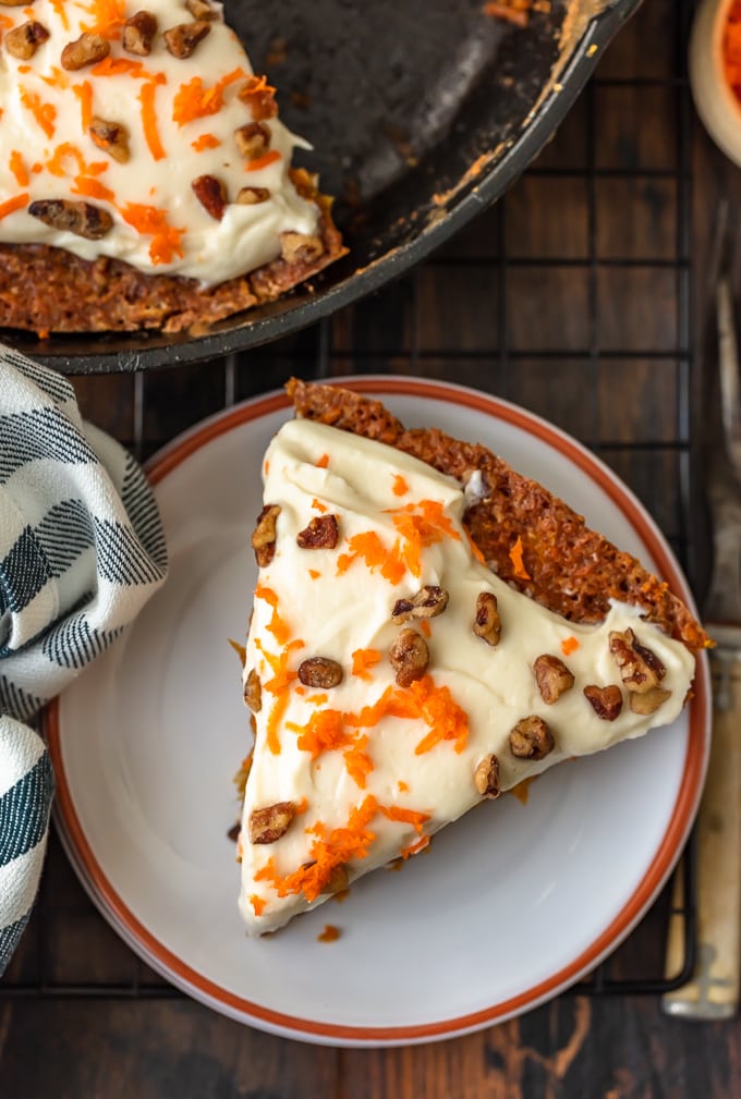 a triangular slice of carrot cake on a small white plate