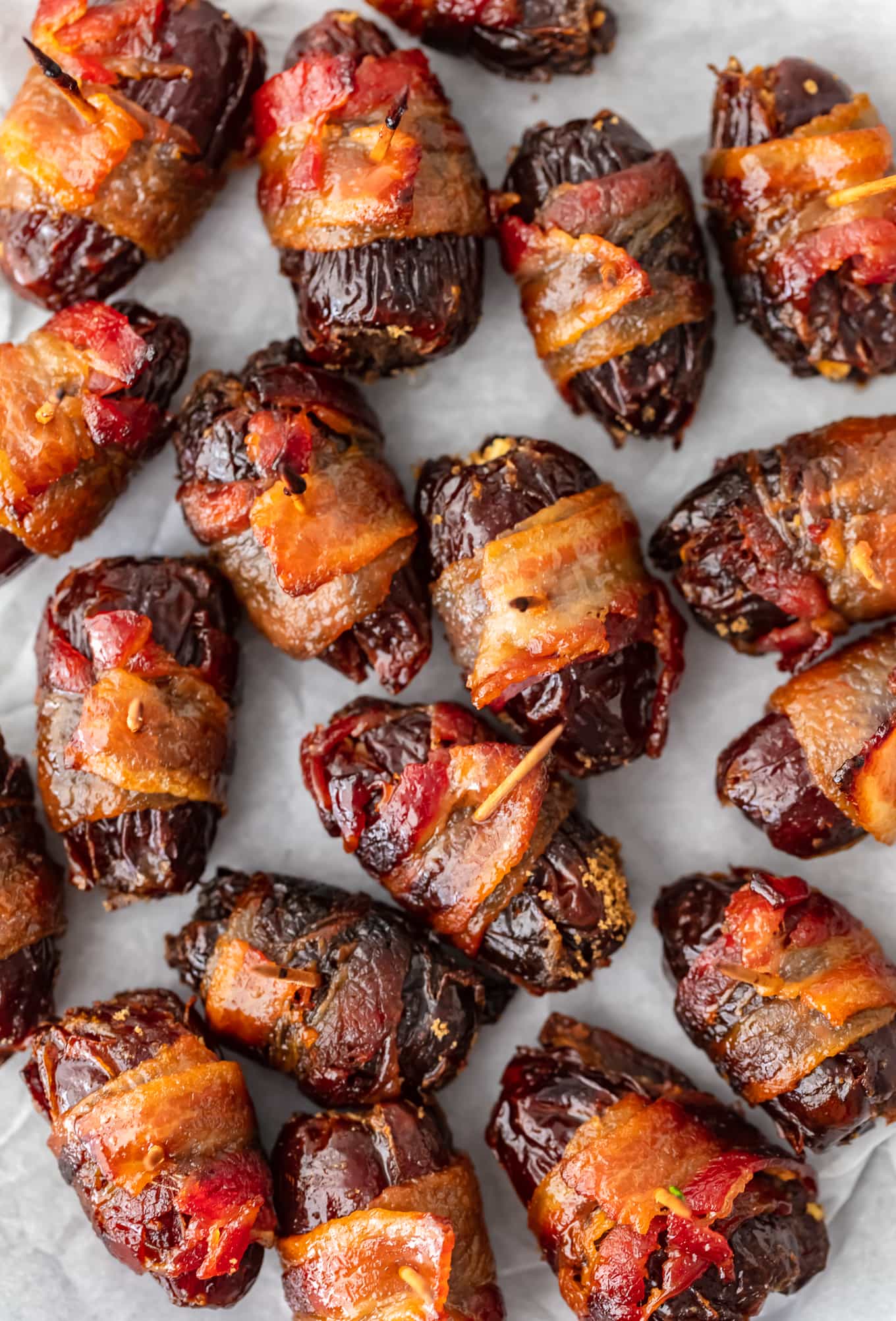 bacon wrapped dates arranged on parchment paper