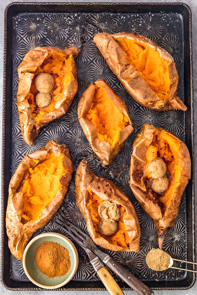 baked sweet potatoes sliced open, arranged on a baking sheet