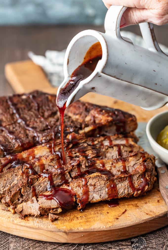 pouring bbq sauce over brisket