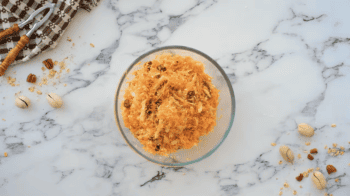 A bowl of morning glory muffins on a marble table.