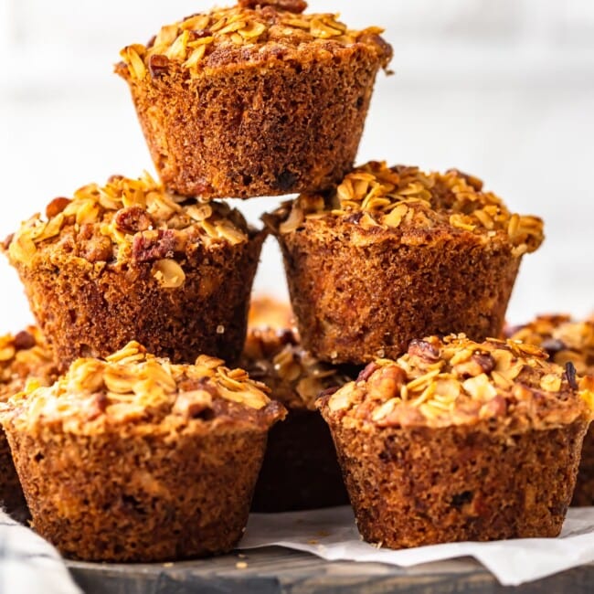 A stack of morning glory muffins on a wooden plate.