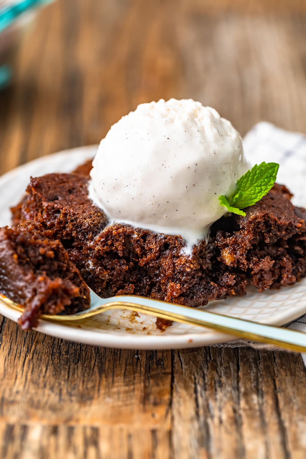 gingerbread pudding cake on a plate topped with vanilla bean ice cream