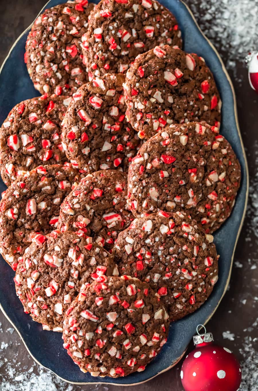 overhead view of a plate of chocolate cookies with peppermint chips