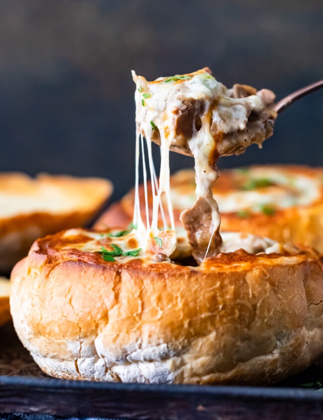 A close up of cheesy soup in breadbowl