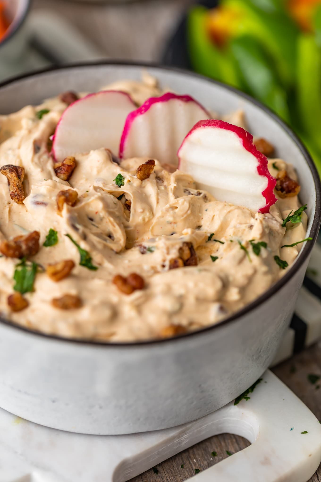 bowl of blue cheese dip with three radish slices dipped in