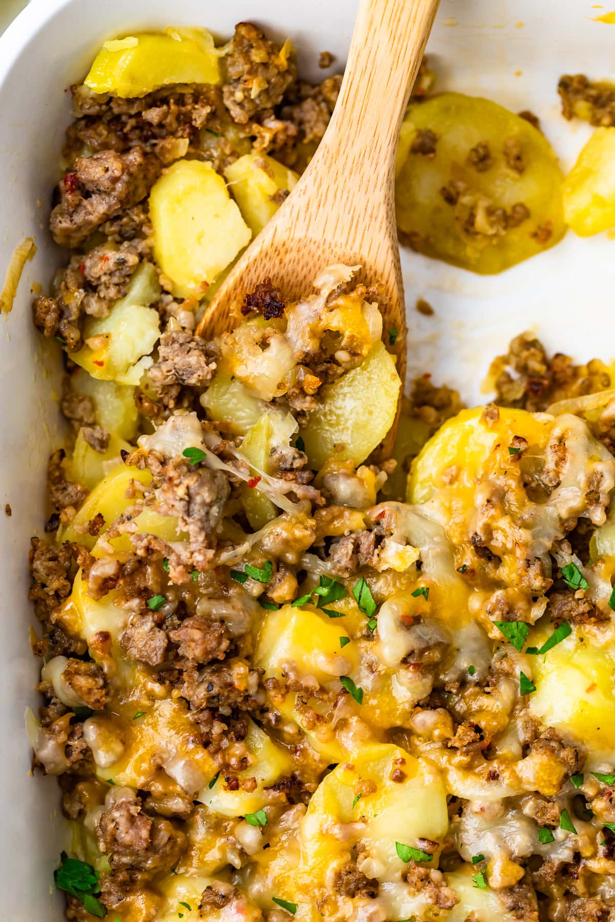 cheesy sausage and potatoes recipe in a white dish