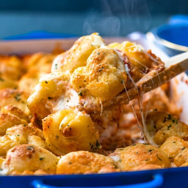 Pizza Casserole is the perfect cheese-filled dish to serve for a fun dinner! This pepperoni pizza casserole recipe is made with layers of cheese, sauce, and pepperonis, then topped with balls of pizza dough and brushed with garlic butter. You're left with a DELICIOUS garlic bread pizza bake that everyone will love!