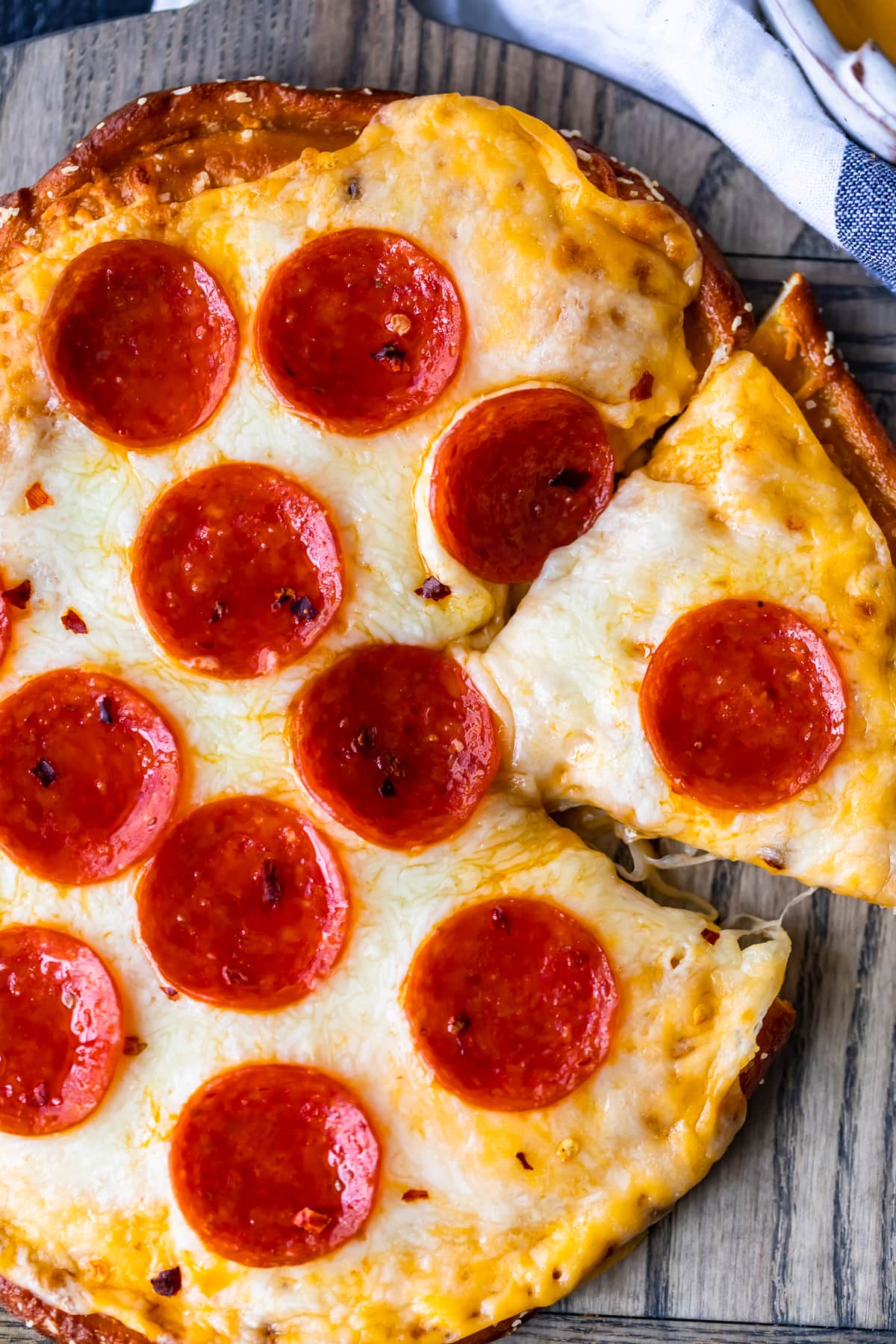 overhead shot of piece cut out of soft pretzel crust pizza with pepperoni little caesar's copycat recipe