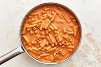 ziti noodles tossed in creamy marinara sauce in a saucepan.