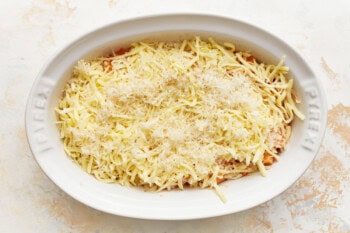 layers of cheese over creamy sauced noodles in an oval baking dish.