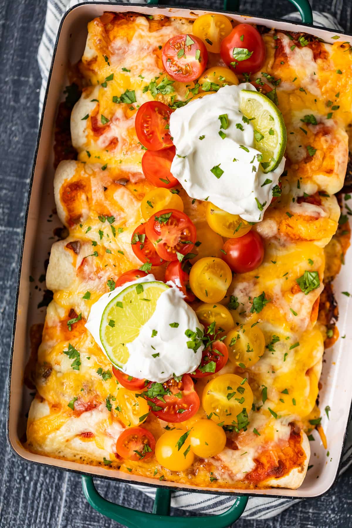 best beef enchilada recipe, covered with cheese, tomatoes, sour cream, and more