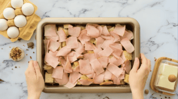 ham on top of english muffin pieces in a casserole dish.