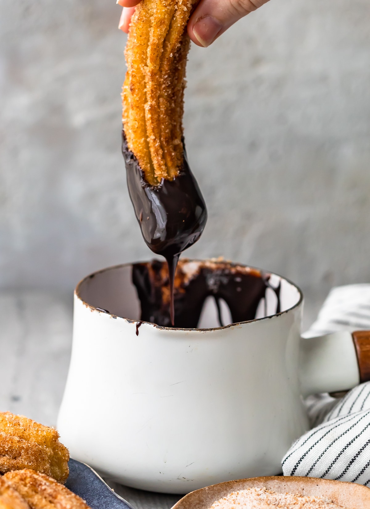 dipping gluten free churro in chocolate sauce