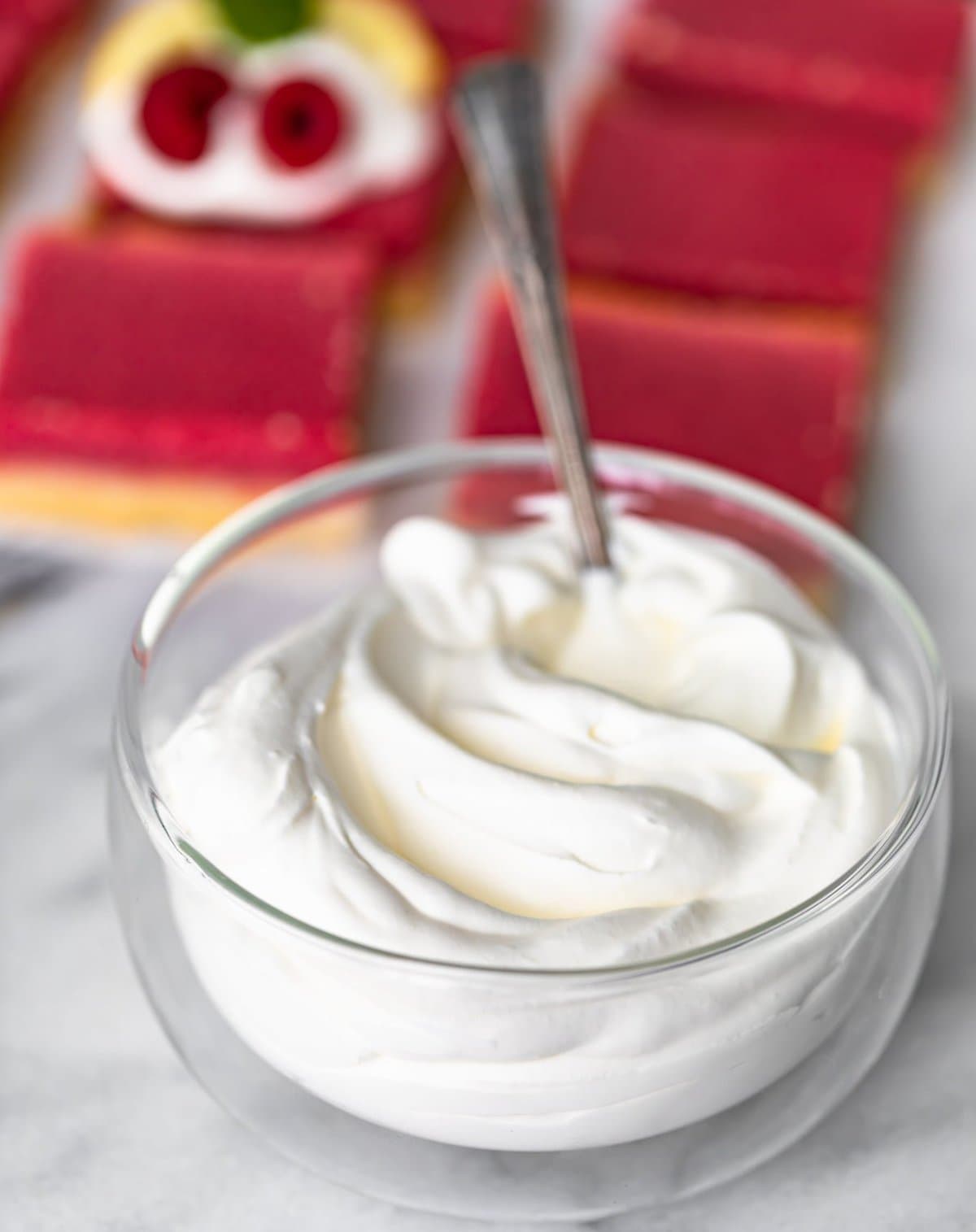 bowl of whipped cream with dessert bars in the background