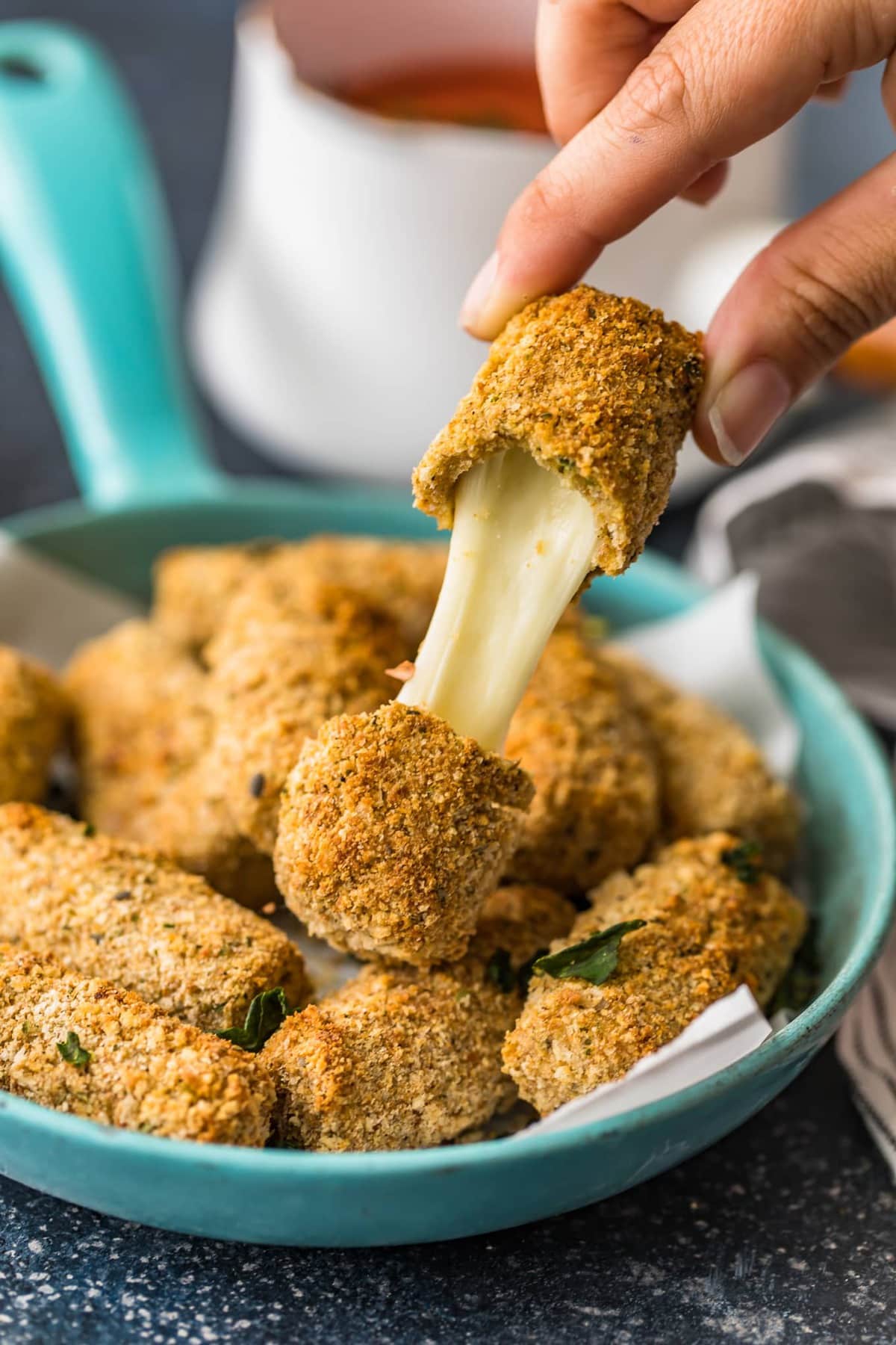 A baked mozzarella stick pulled apart to show stringy cheese